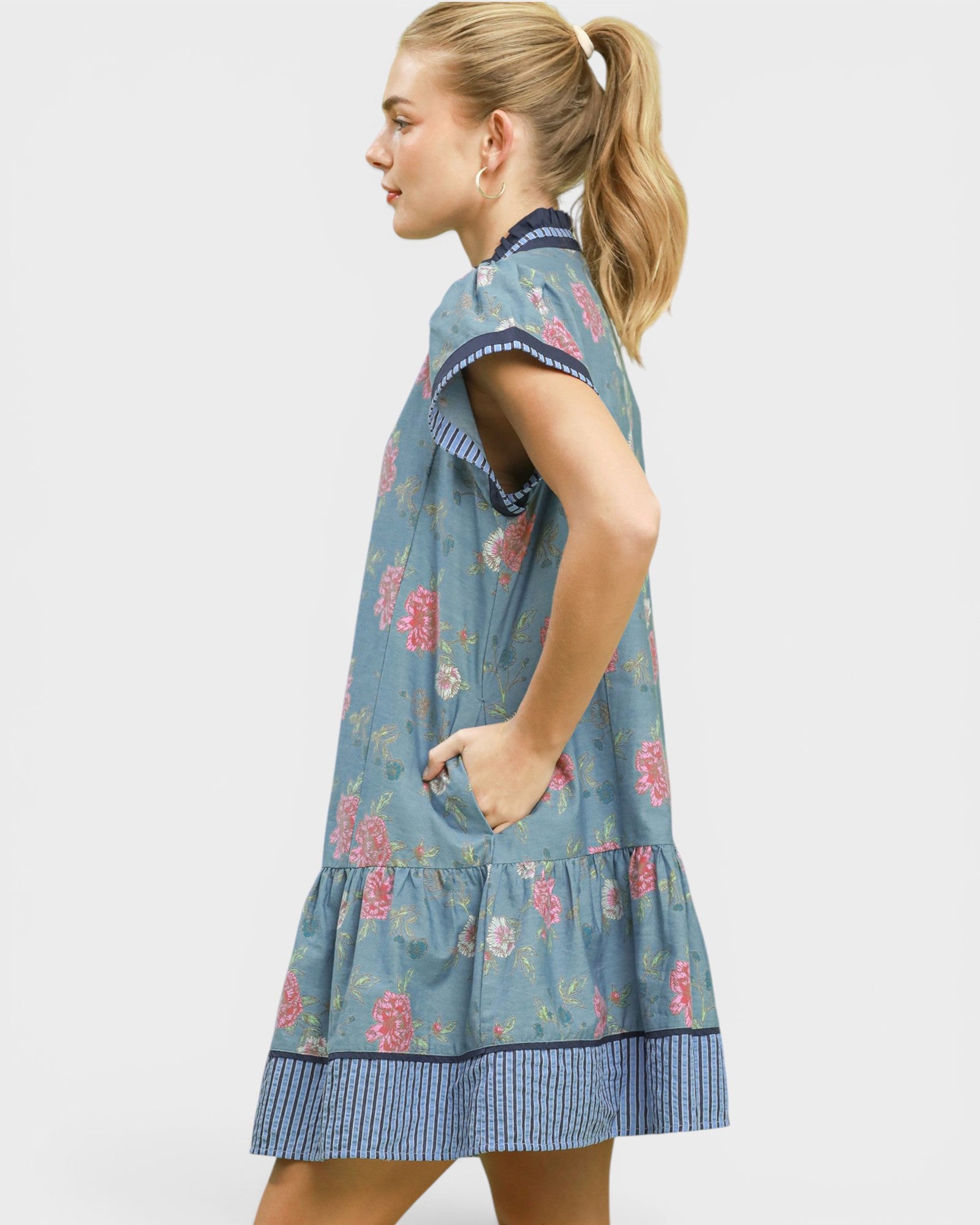 Woman wearing a blue floral dress on a white background