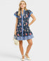 Woman wearing a floral dress with blue accents on a white background