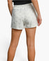 White textured shorts with a raised floral pattern, shown on a model from the back against a light gray background.