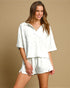 Woman wearing a white outfit on a beige background