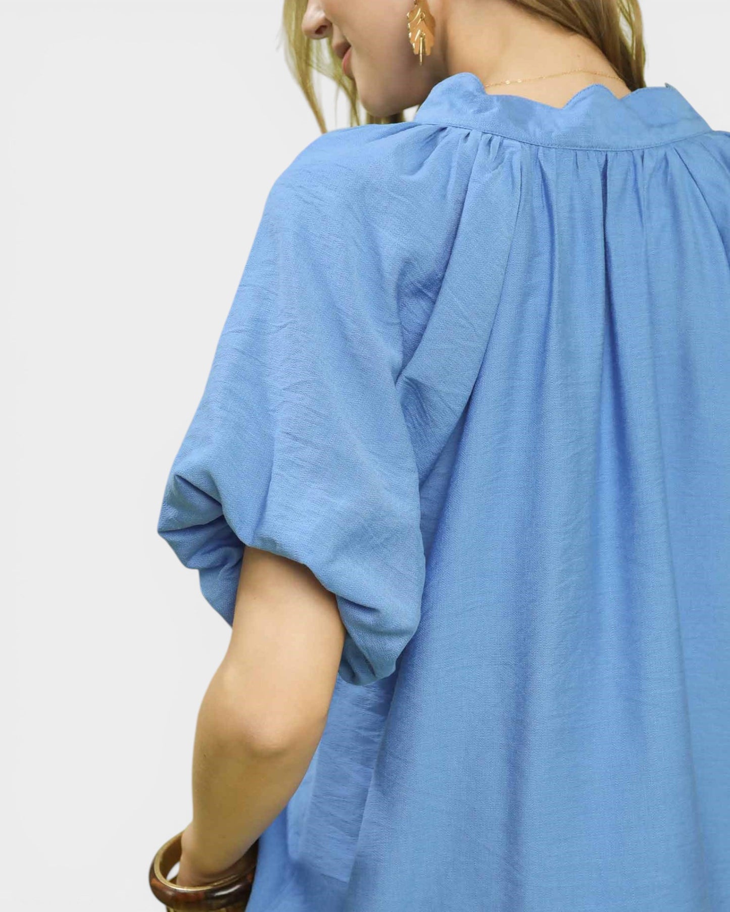 Blue garment worn by a person on a white background