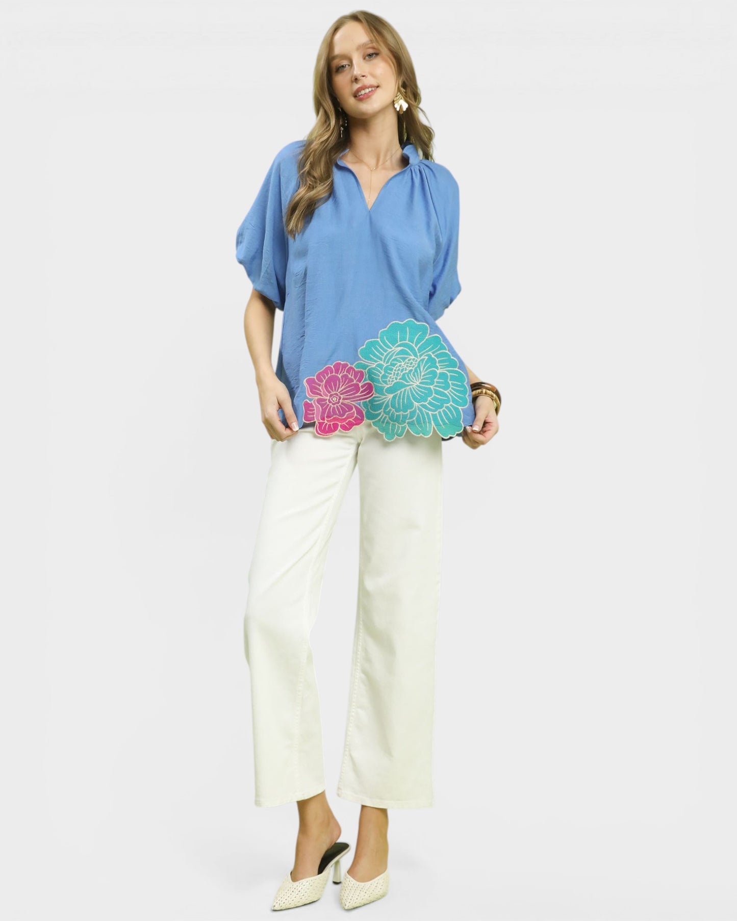 Woman holding a colorful clutch bag against a plain background