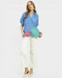 Woman holding a colorful clutch bag against a plain background