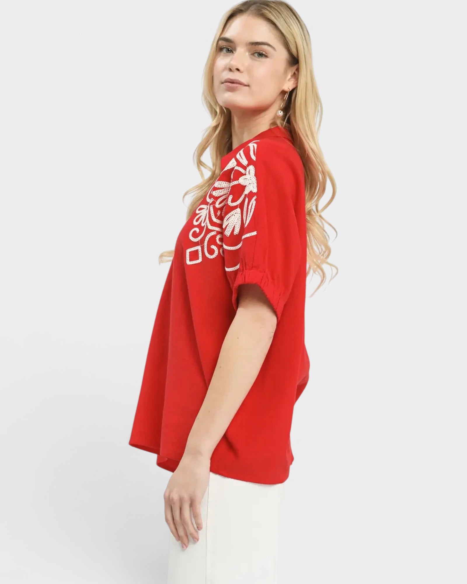 Woman wearing a red oversized t-shirt with white graphics on a white background