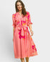 Woman wearing a pink floral dress on a white background