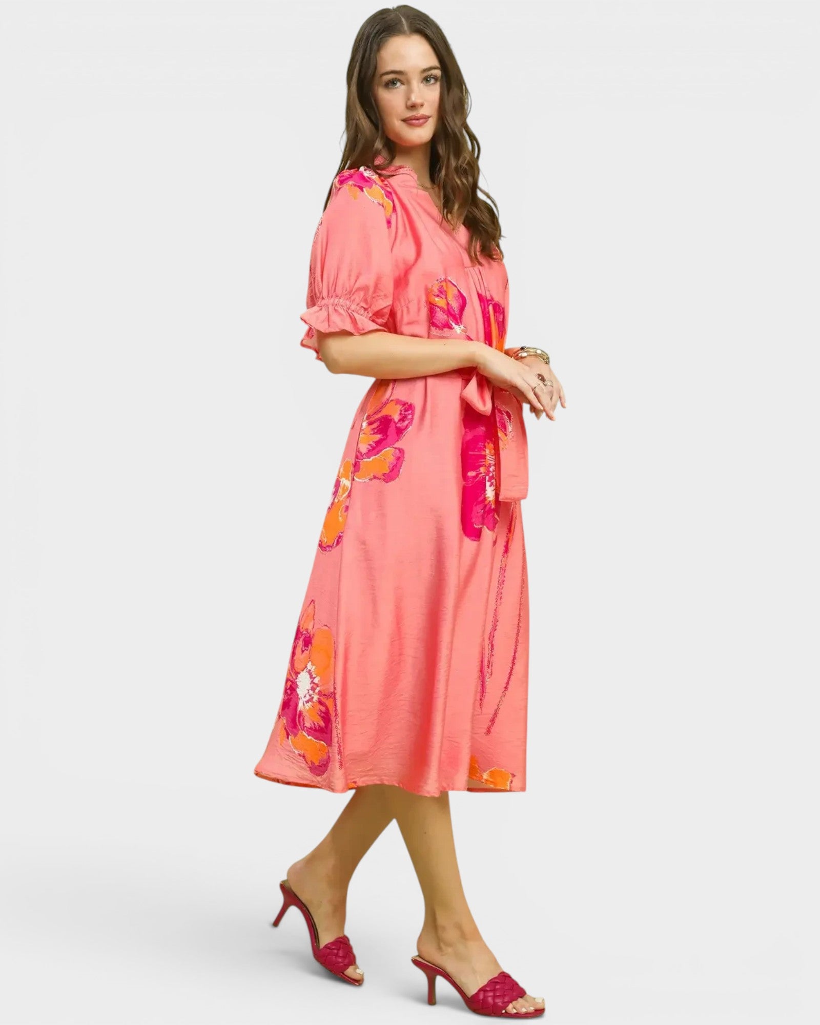 Woman wearing a pink floral dress on a white background