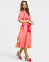 Woman wearing a pink floral dress on a white background