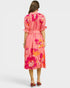 Woman wearing a pink floral dress on a white background