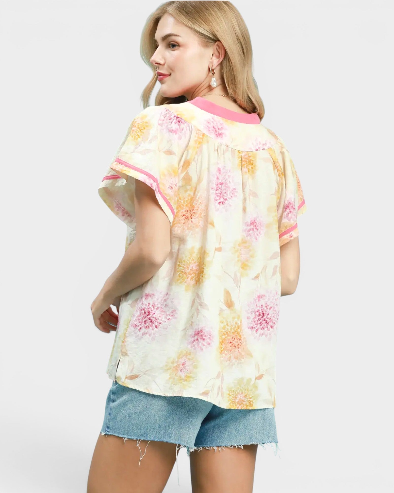 Woman wearing a floral kimono-style top with a white background