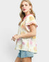 Woman wearing a floral blouse with ruffled sleeves on a white background