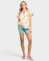 Woman wearing a floral blouse and denim shorts on a white background