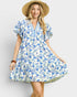 Woman wearing a blue floral dress and straw hat on a white background