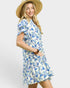 Woman wearing a blue floral dress and straw hat on a white background