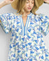 Woman wearing a floral dress with blue flowers on a white background