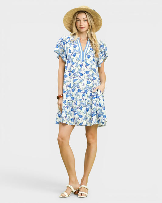 Woman wearing a blue floral dress and straw hat on a white background