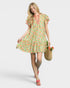 Woman wearing a floral dress holding a bag on a white background
