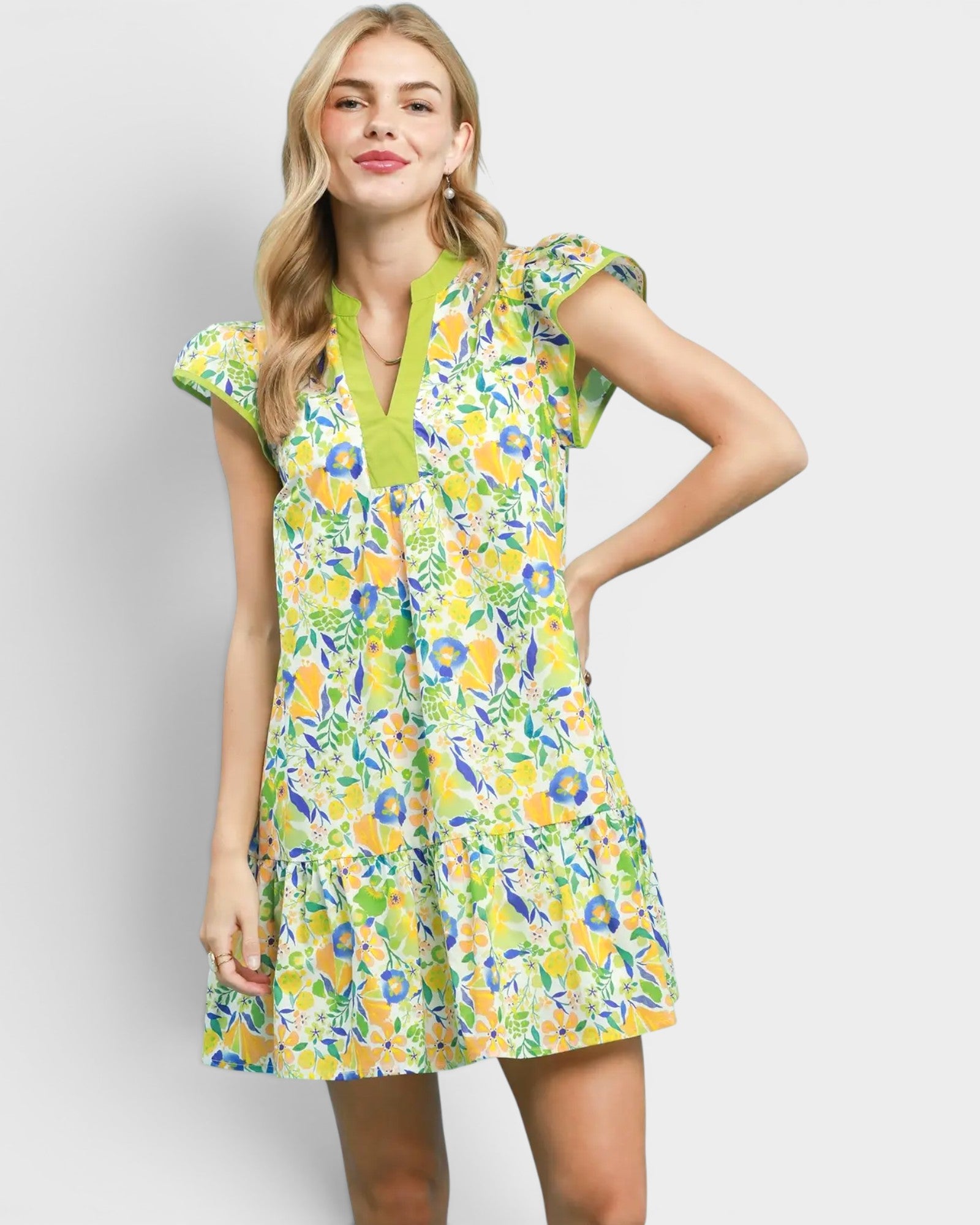 Woman wearing a colorful floral dress on a plain background