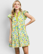 Woman wearing a colorful floral dress on a plain background