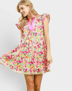 Woman wearing a colorful floral dress on a plain background
