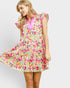 Woman wearing a colorful floral dress on a plain background