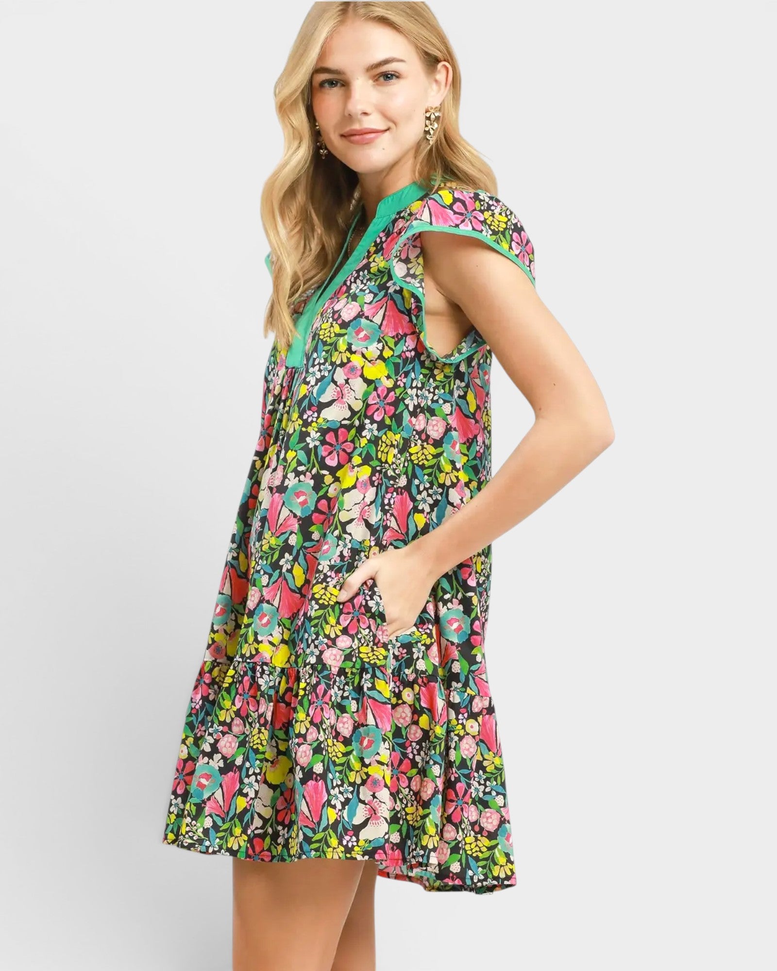 Woman wearing a colorful floral dress on a light gray background