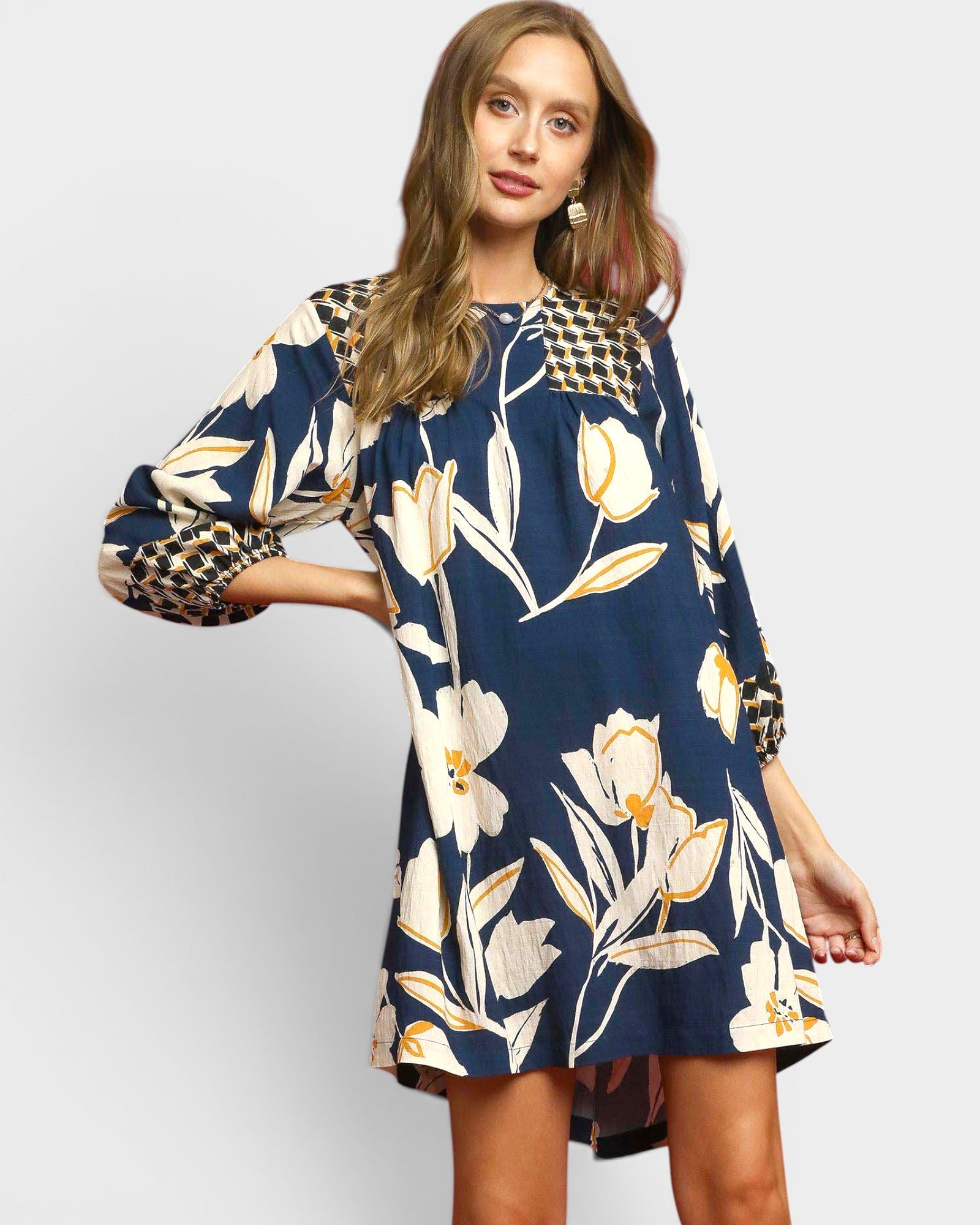 Woman wearing a navy floral dress with a plain background
