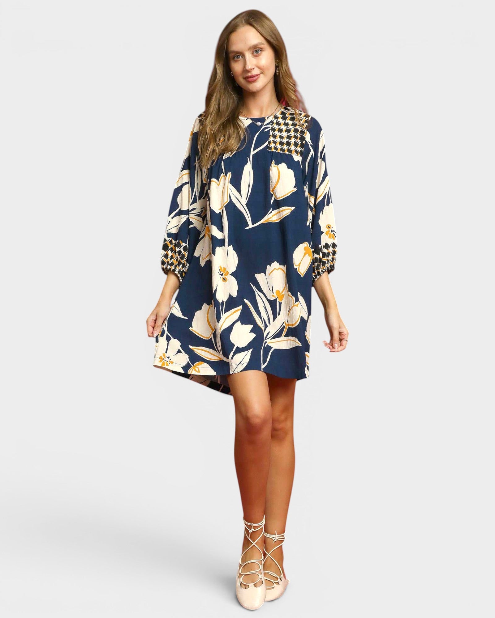 Woman wearing a navy floral dress on a white background