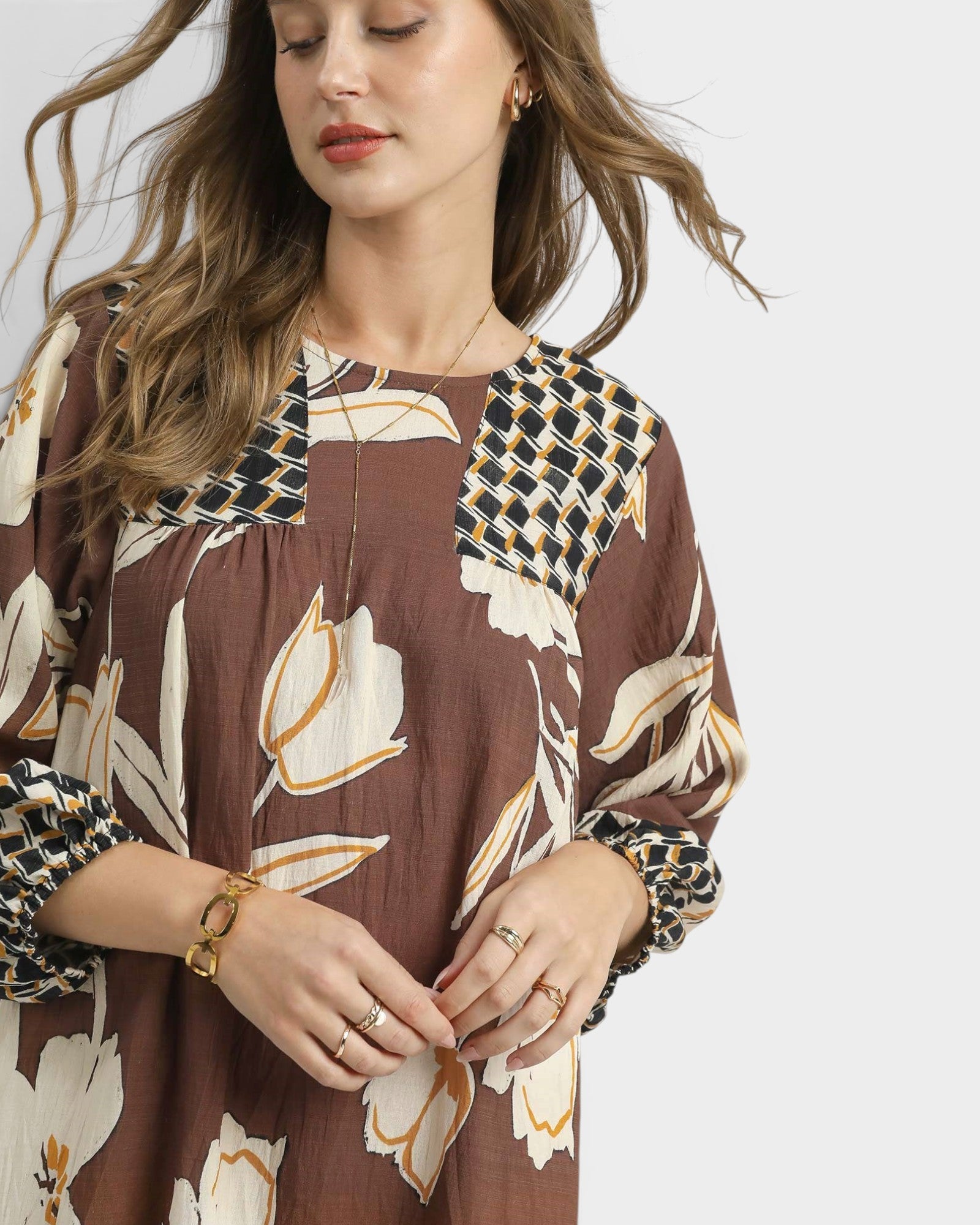 Woman wearing a brown floral dress with a white background