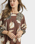 Woman wearing a brown floral dress with a white background
