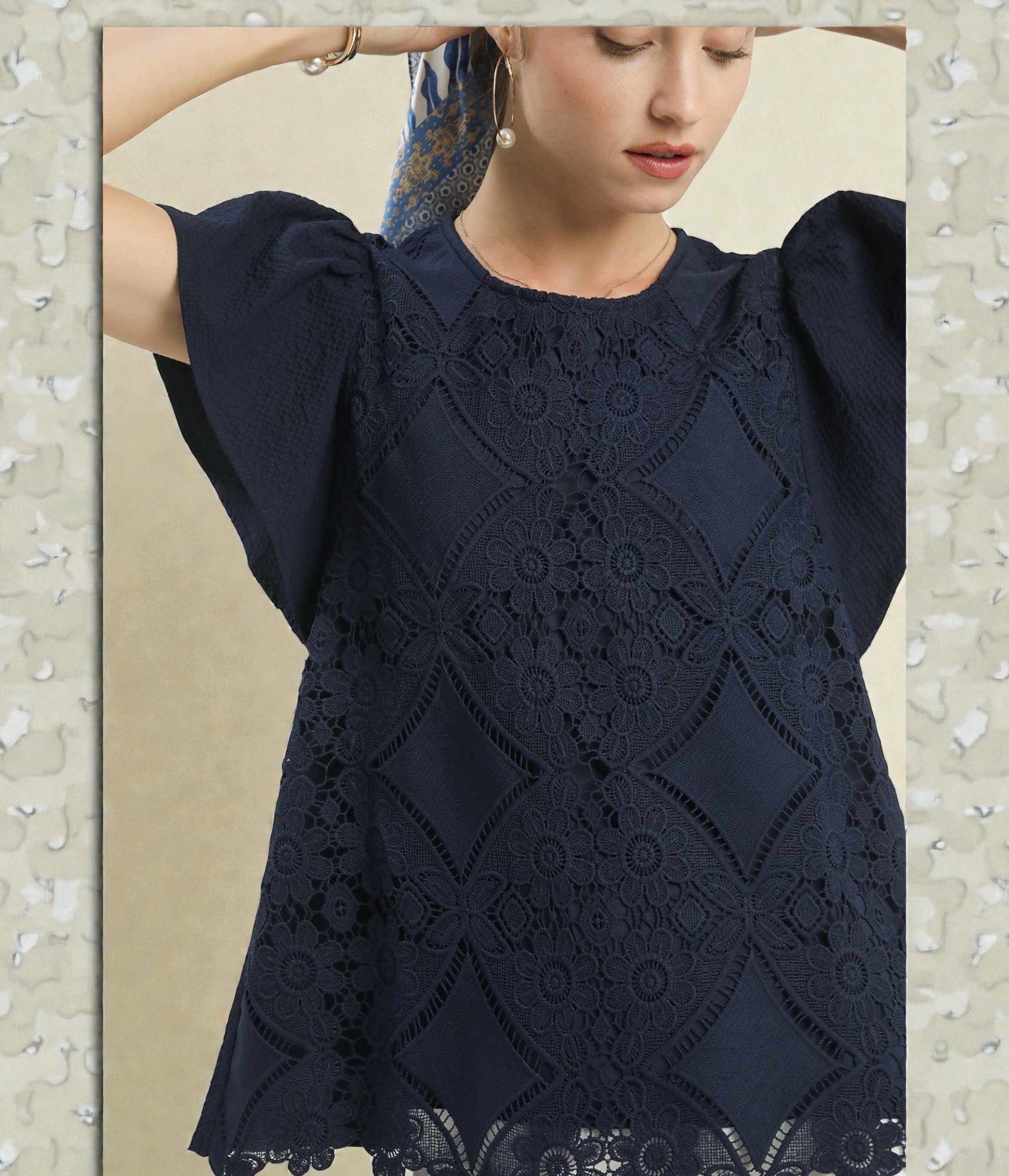 Navy blue lace top worn by a model on a neutral background