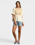 Woman wearing a lace top and denim shorts on a white background
