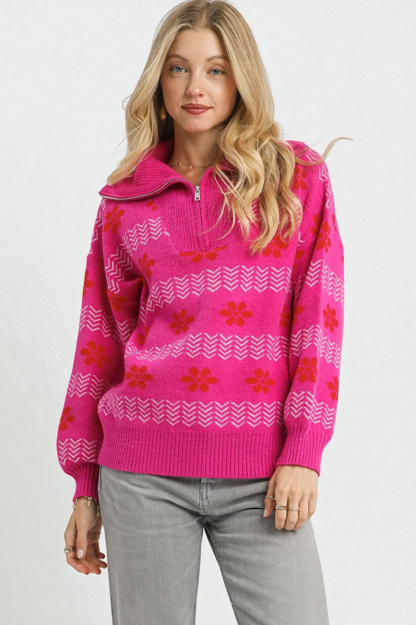 Woman wearing a pink patterned sweater against a white background