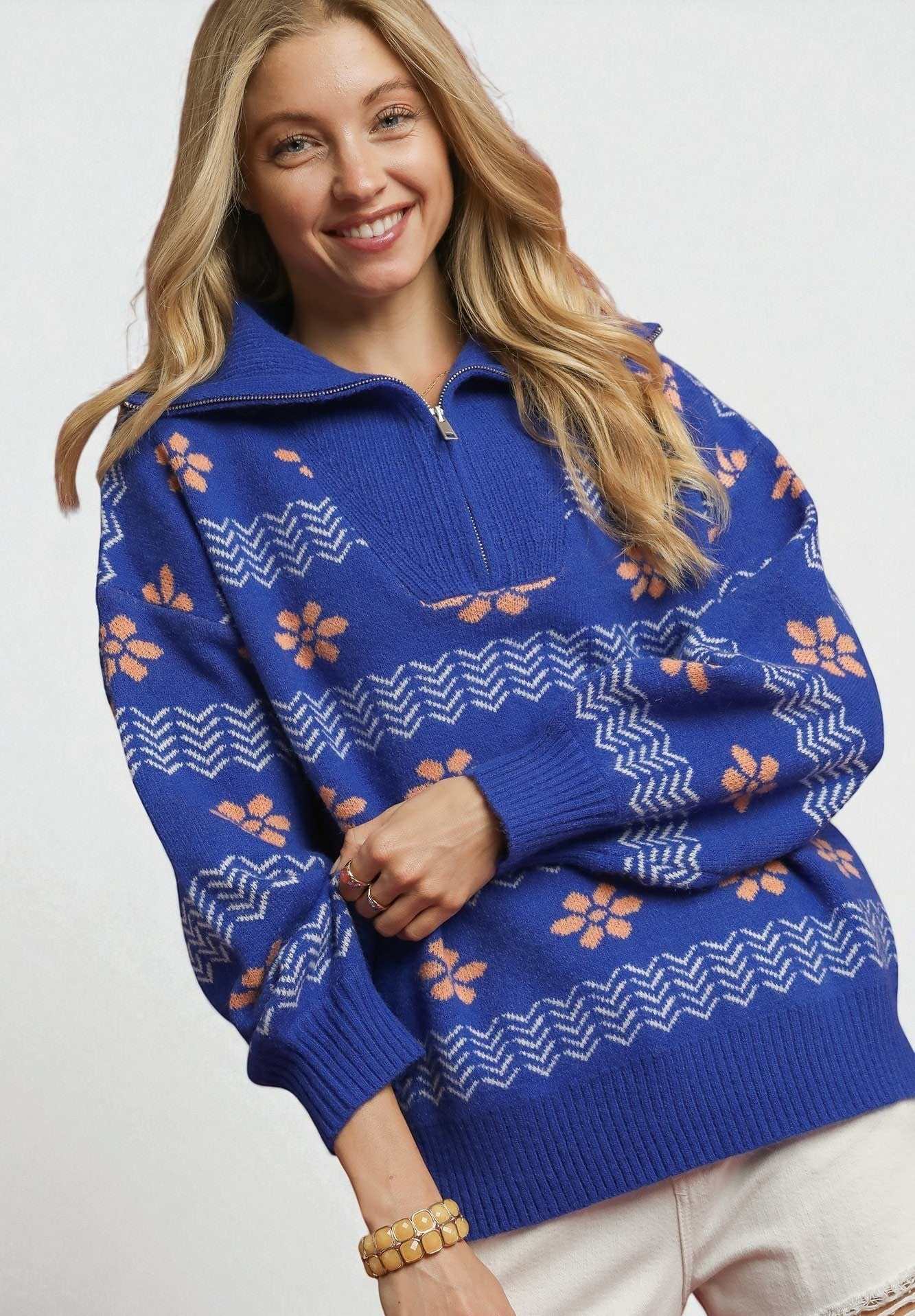 Woman wearing a blue patterned sweater with a white background