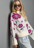 Woman wearing a floral sweater with pink flowers on a gray background