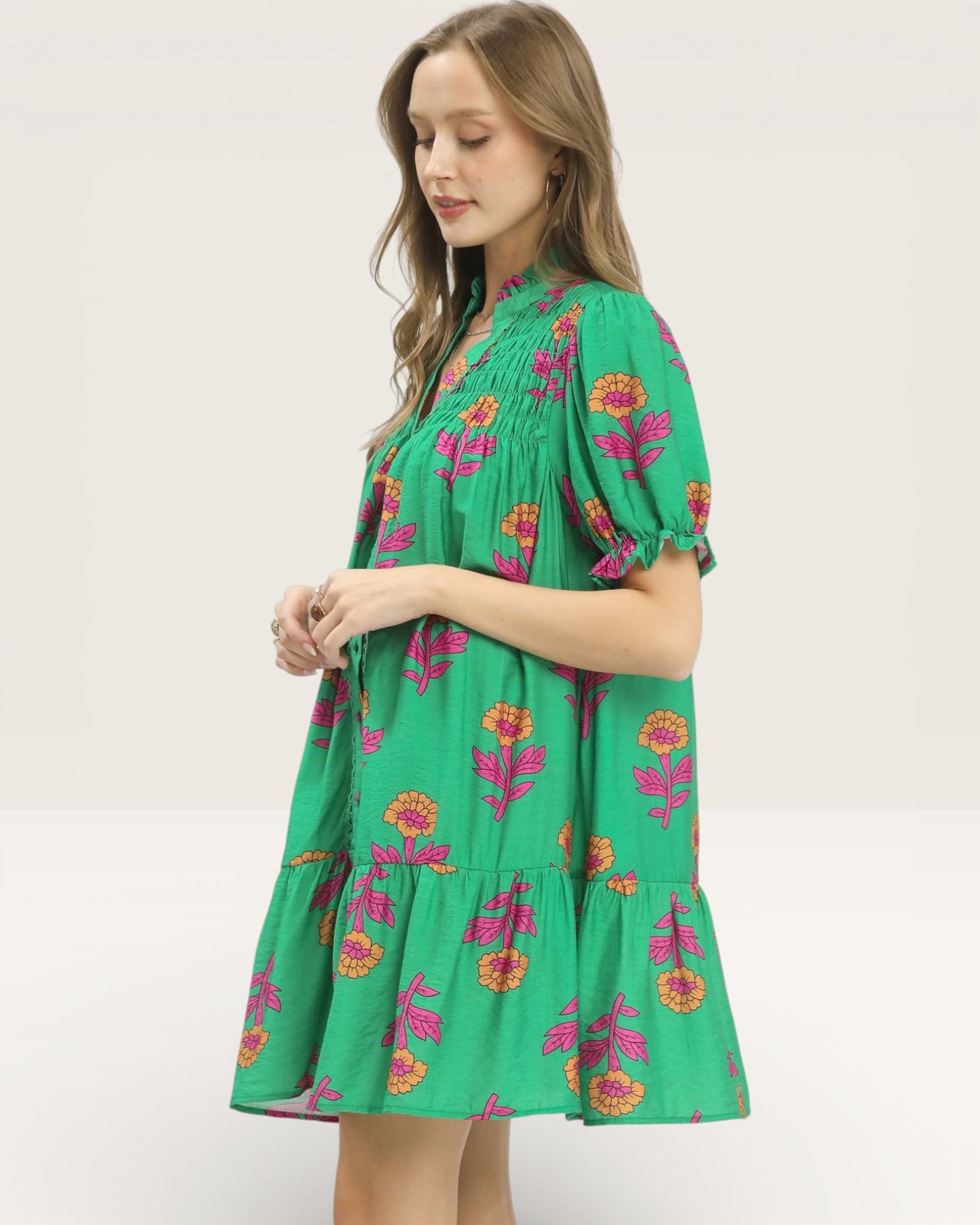 Woman wearing a green floral dress on a white background