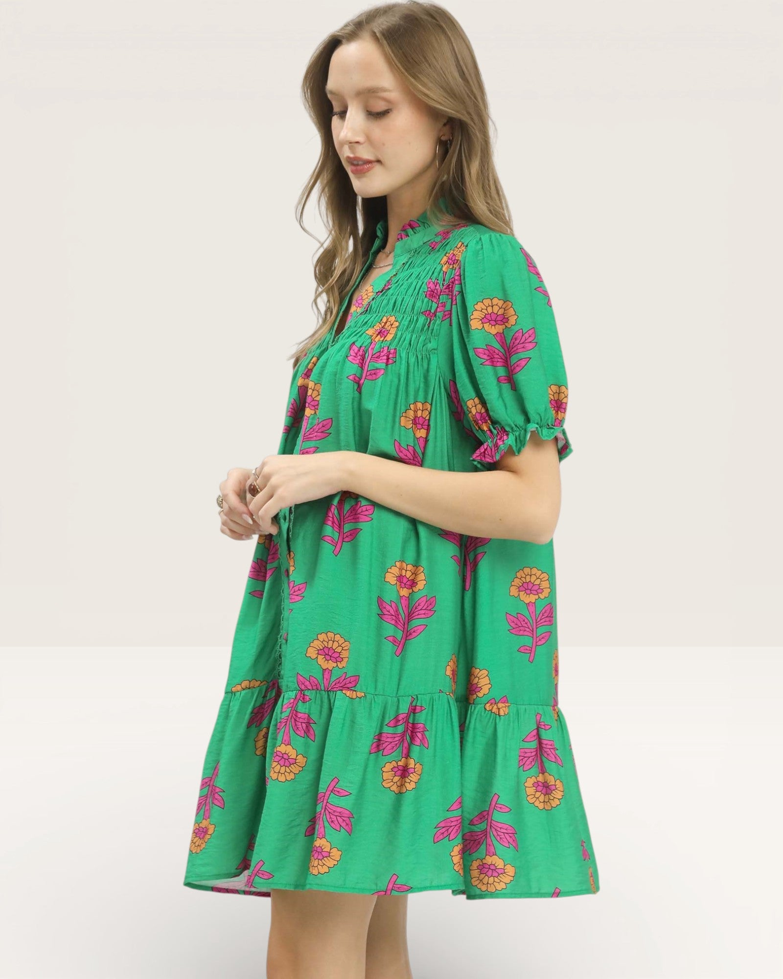 Woman wearing a green floral dress on a white background