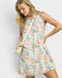 Woman wearing a floral dress with a plain background