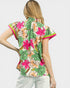 Woman wearing a colorful floral blouse with a plain background