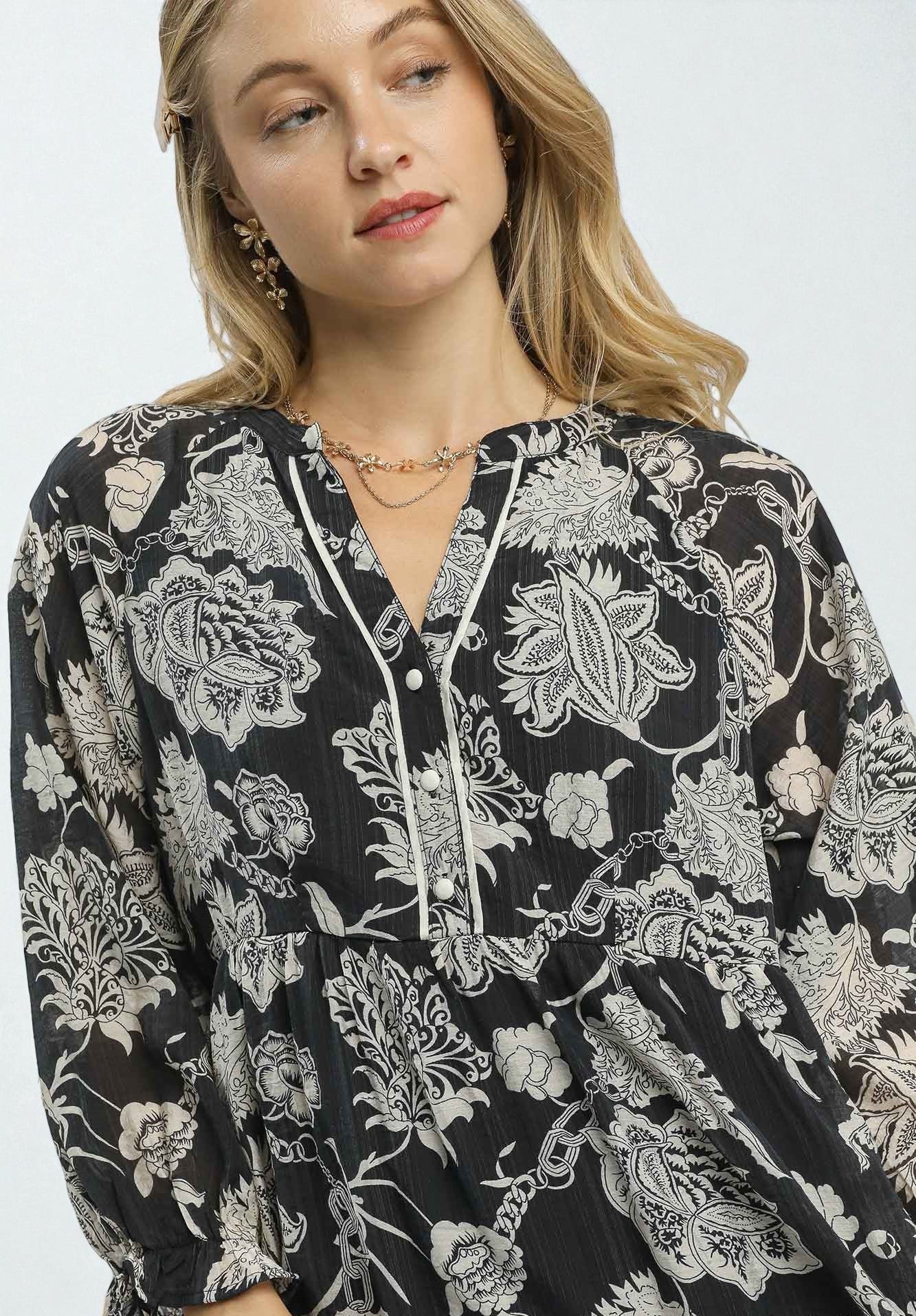 Woman wearing a black floral patterned dress on a white background