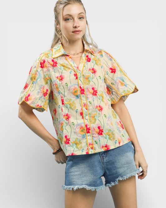 Woman wearing a floral shirt and denim shorts on a white background