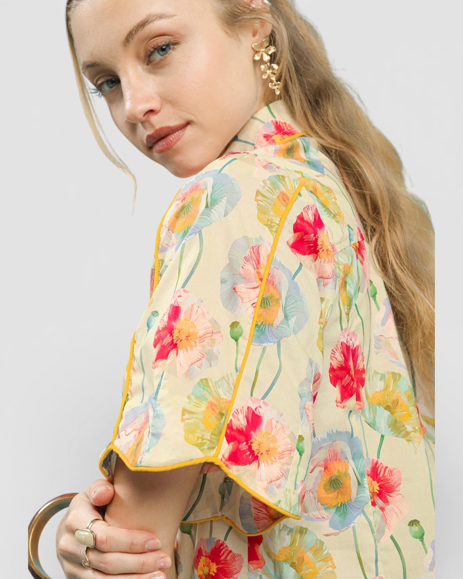 Woman wearing a floral patterned top with a plain background