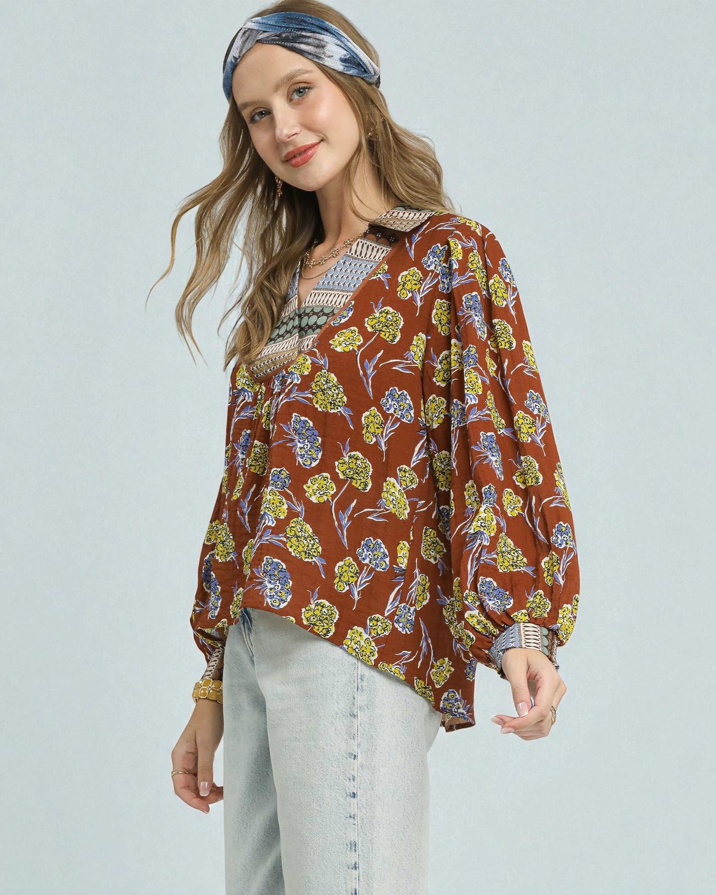 Woman wearing a floral patterned top with a plain background