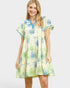 Woman wearing a floral dress with blue accents on a white background
