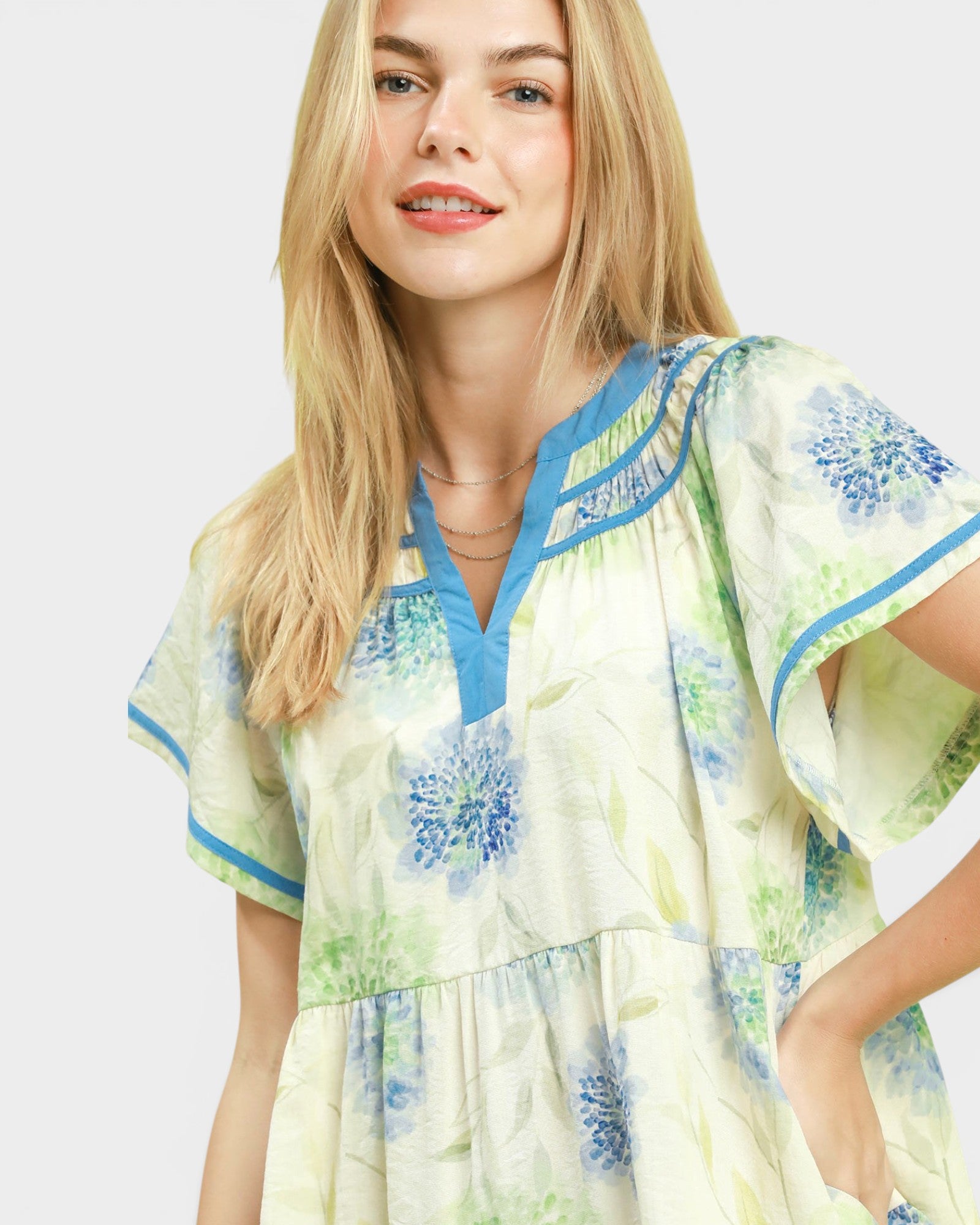Woman wearing a floral dress with blue accents on a white background