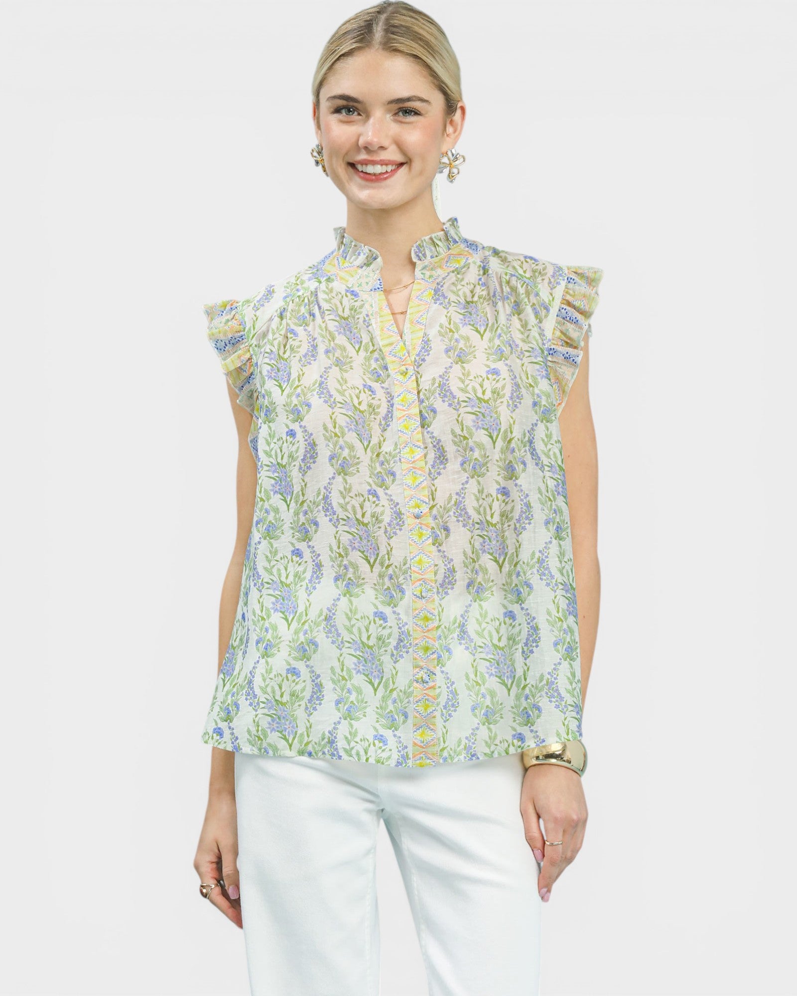 Woman wearing a floral sleeveless blouse with a plain background