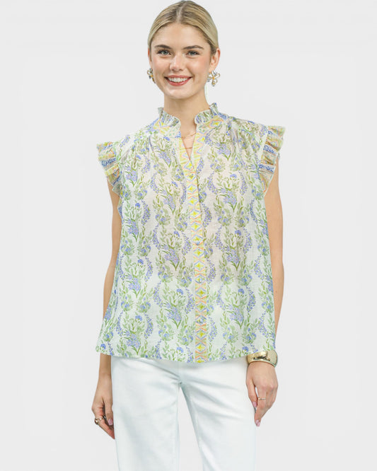 Woman wearing a floral sleeveless blouse with a plain background