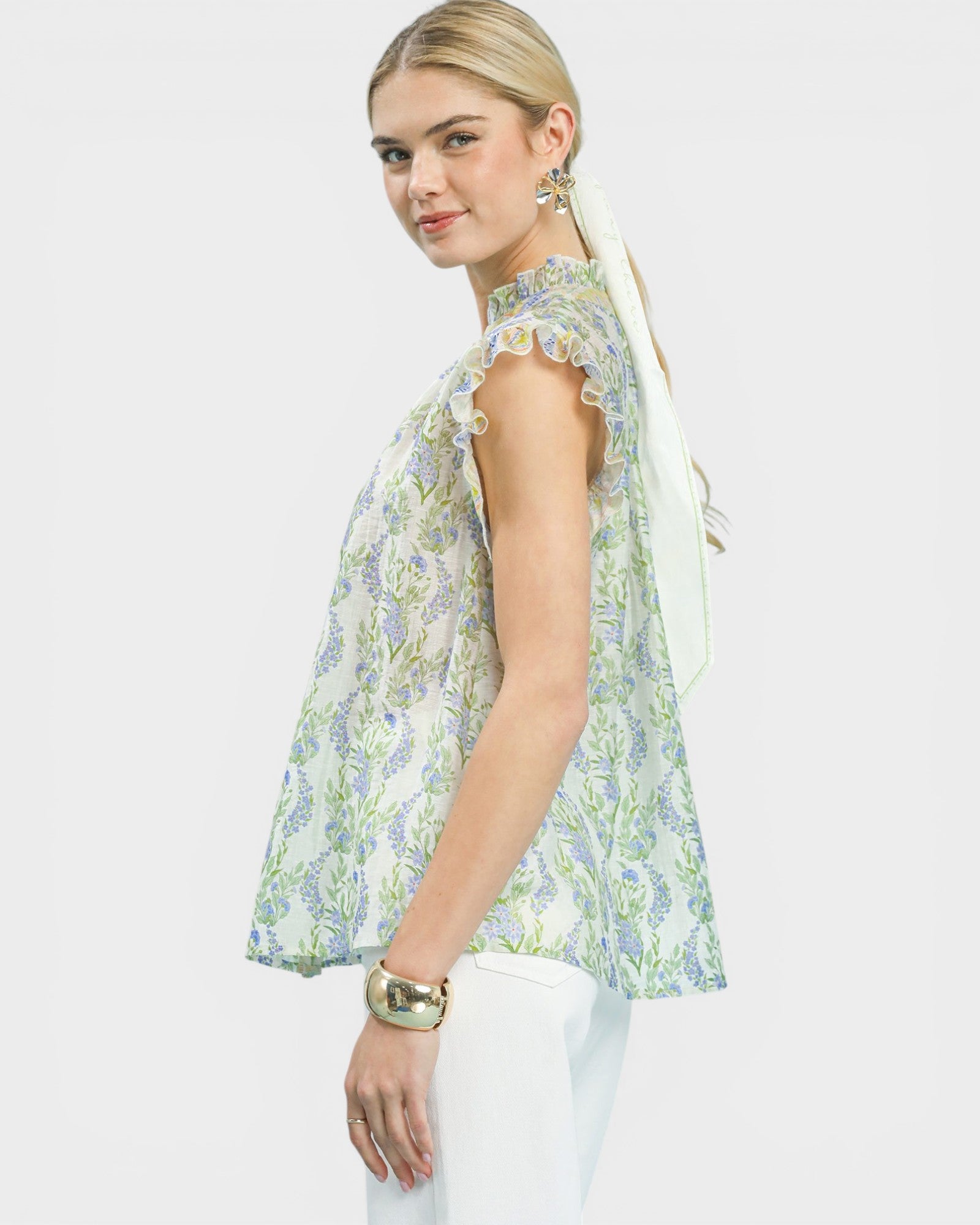 Woman wearing a floral sleeveless top on a white background