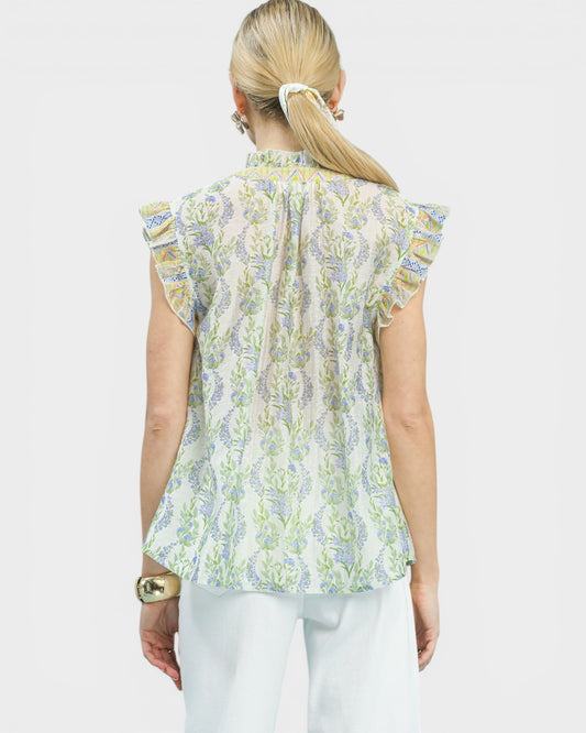 Woman wearing a floral blouse with ruffled sleeves on a white background