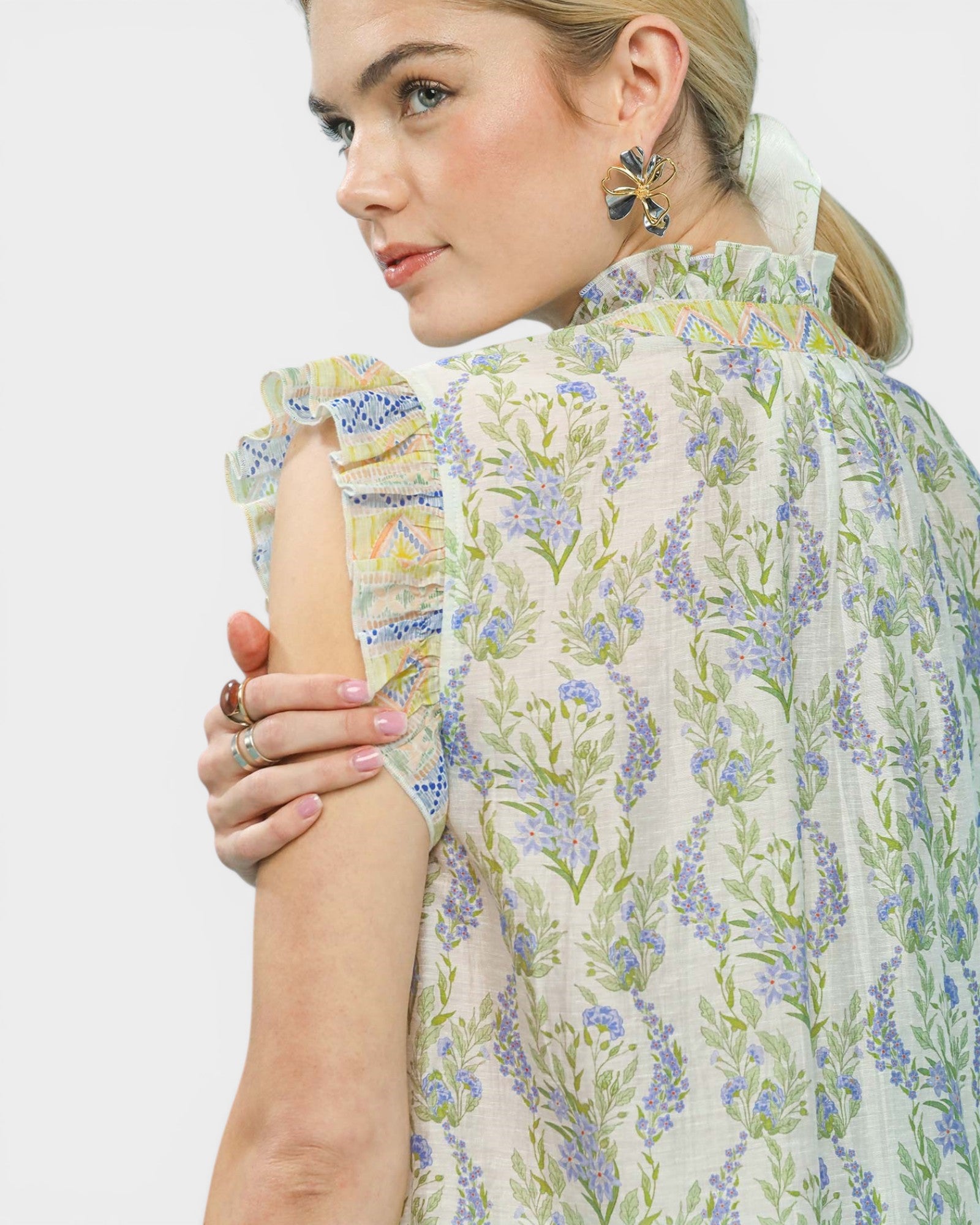 Woman wearing a floral blouse with a plain background