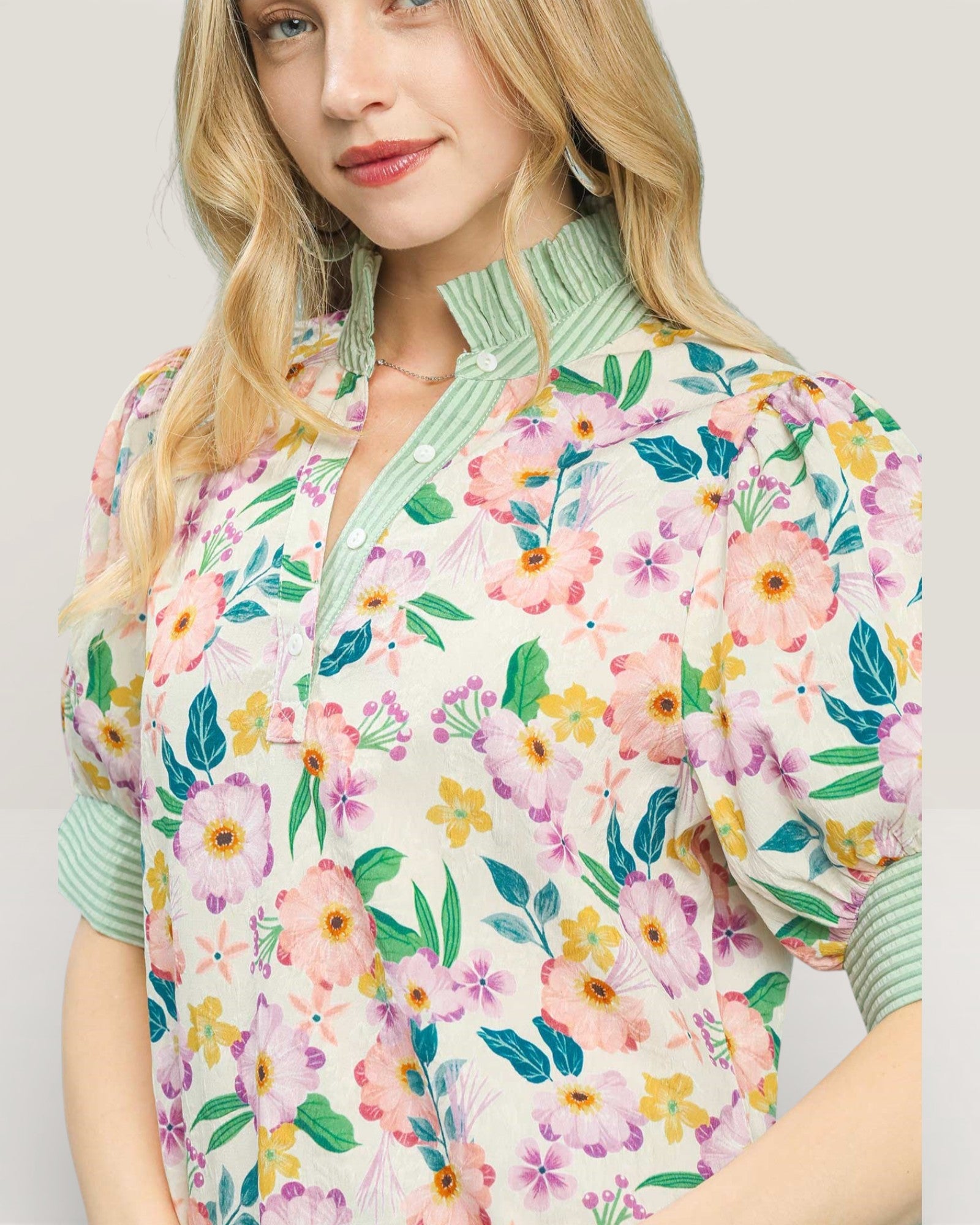 Woman wearing a floral patterned jacket with a plain background